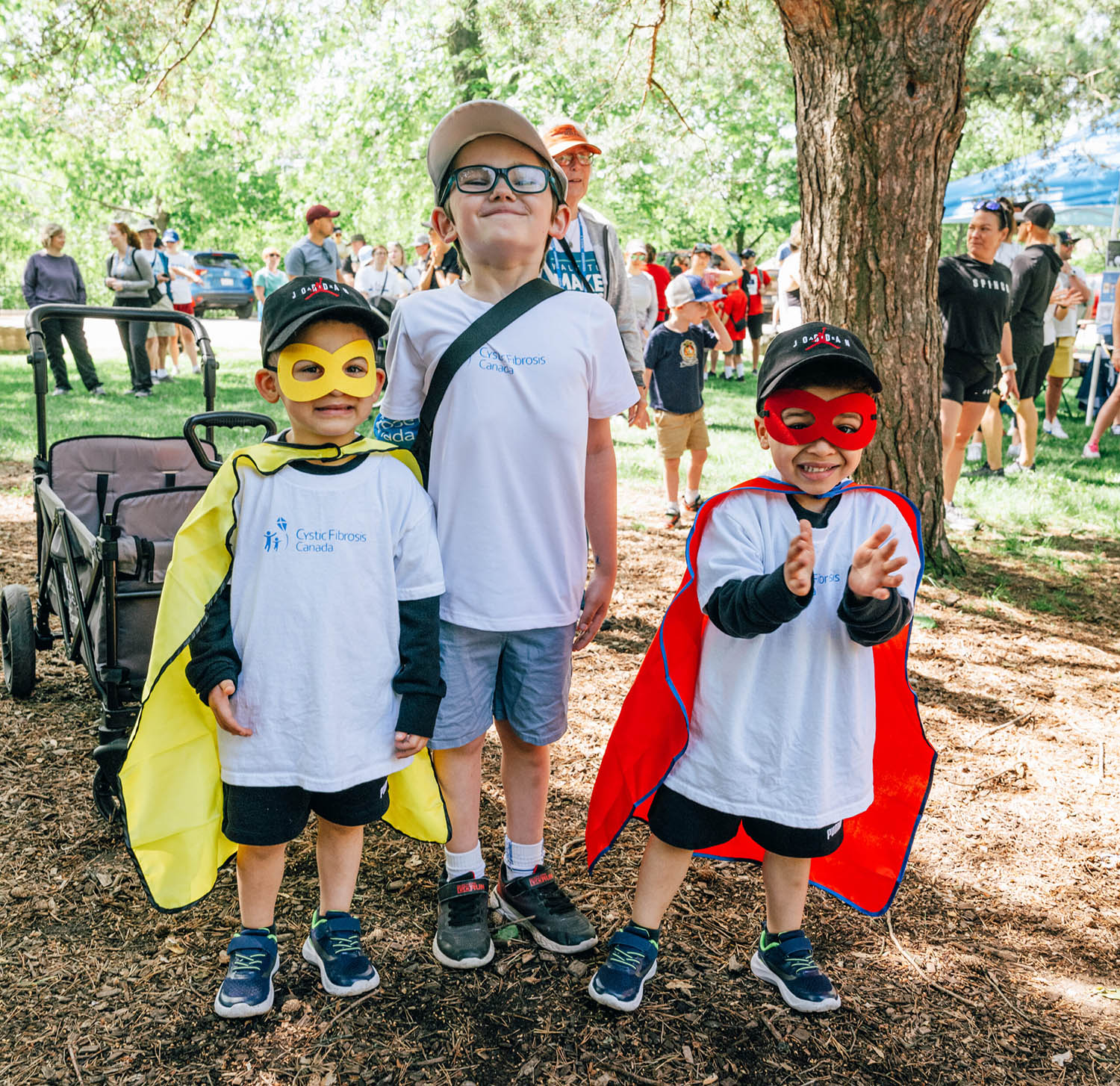 Three junior Walkers wearing superhero capes enjoy the event.