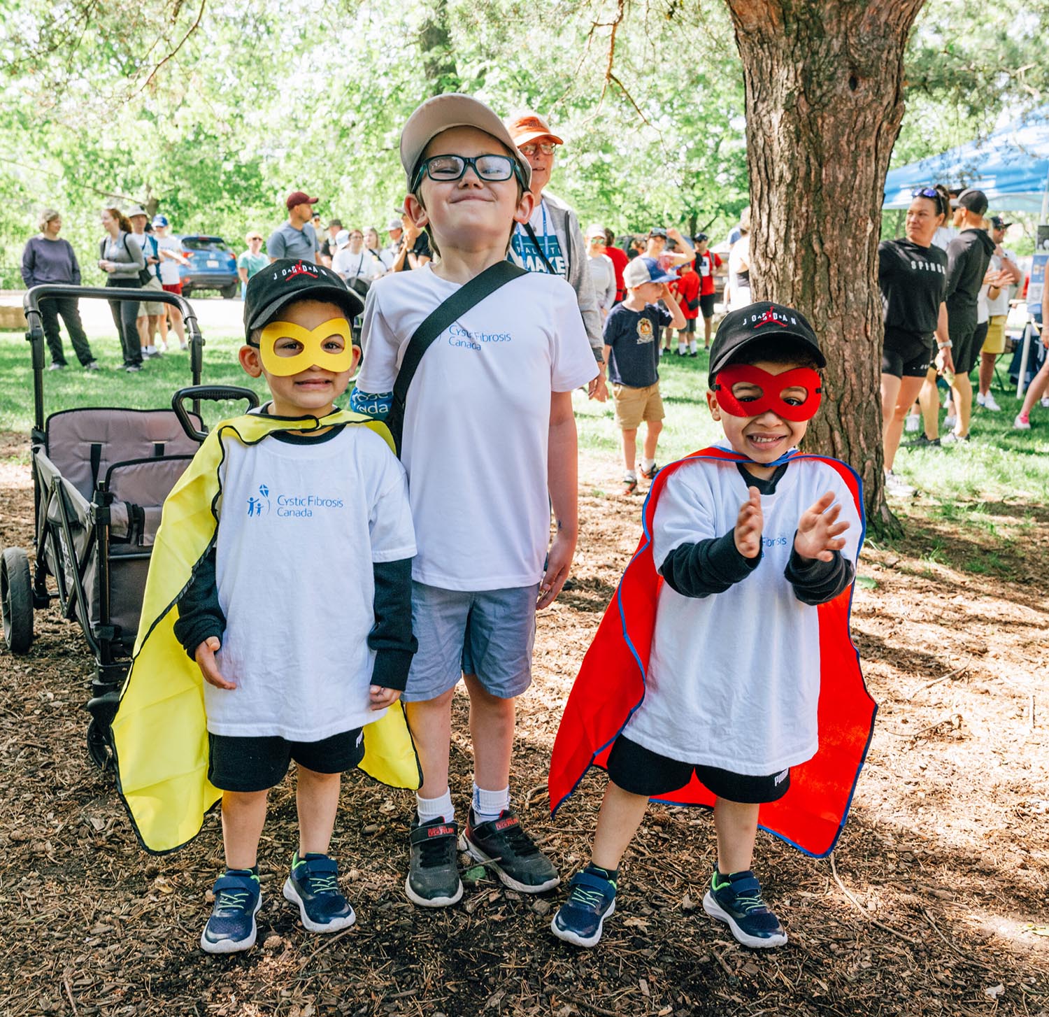 Three junior Walkers wearing superhero capes enjoy the event.